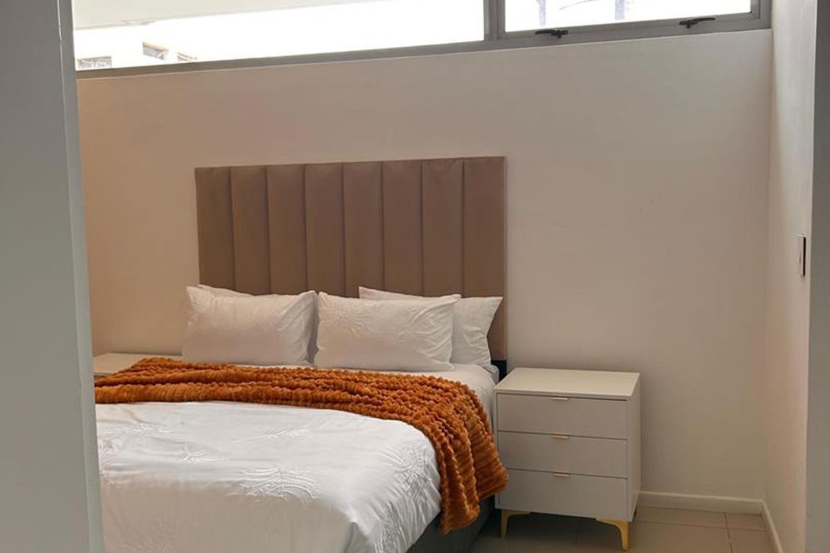 A well-lit bedroom featuring neutral tiled flooring and high-level clerestory windows that provide natural light while maintaining privacy.