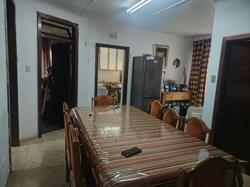 Dining room featuring tiled flooring and direct access to the kitchen area, requiring cosmetic updates to finishes and fixtures.