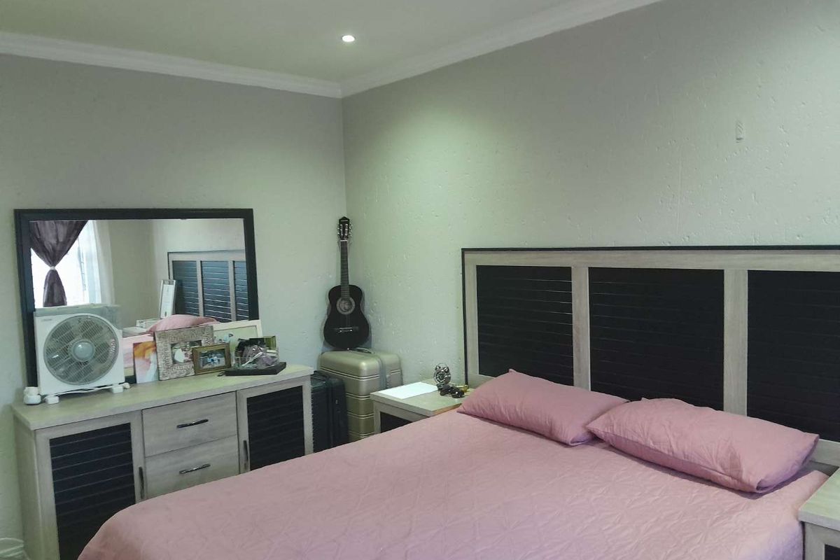 A bedroom featuring neutral wall finishes, recessed ceiling lighting, and crown molding, providing a functional and comfortable sleeping space.