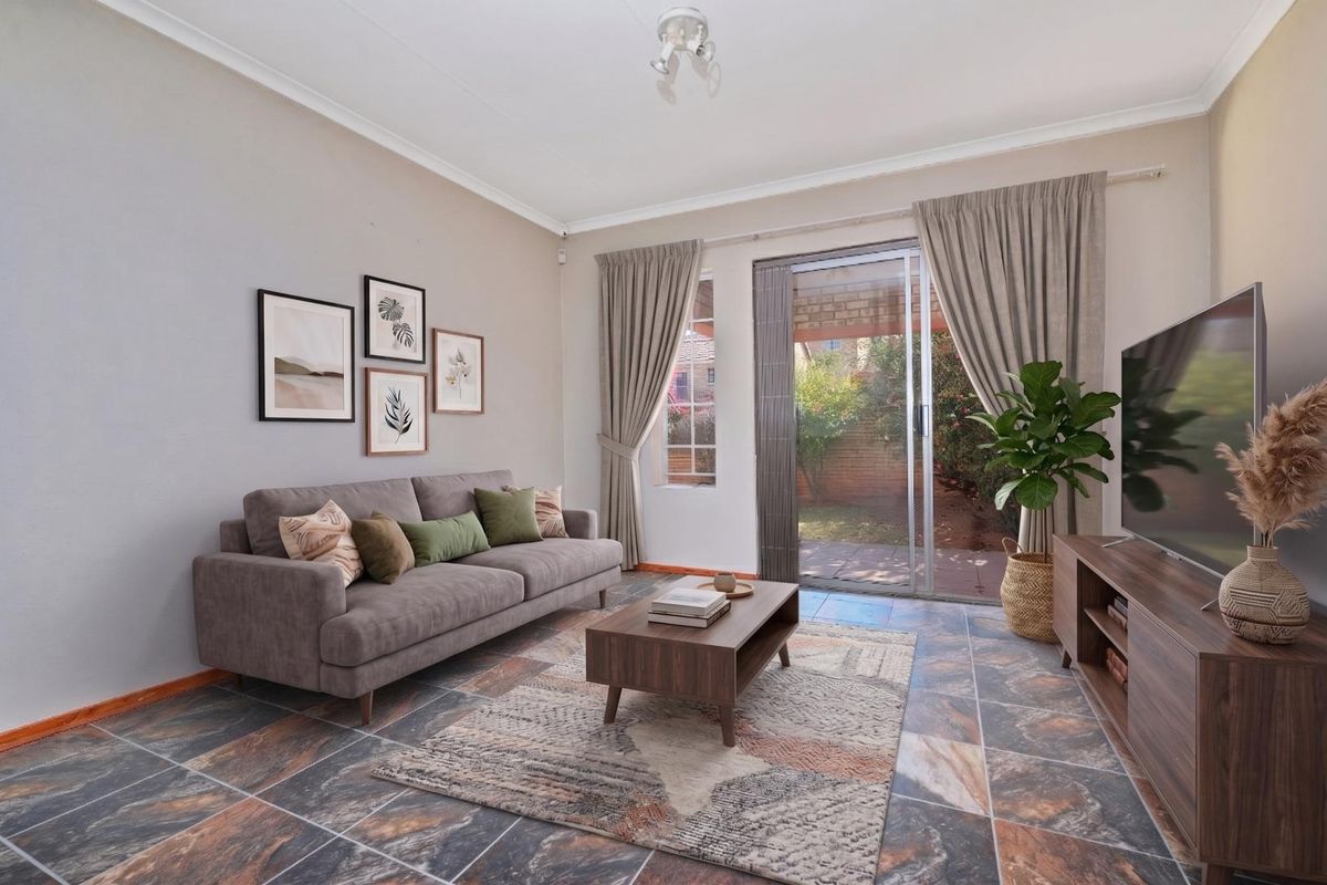 A comfortable living room featuring tiled flooring, a sliding glass door providing access to the rear patio, and neutral wall finishes.