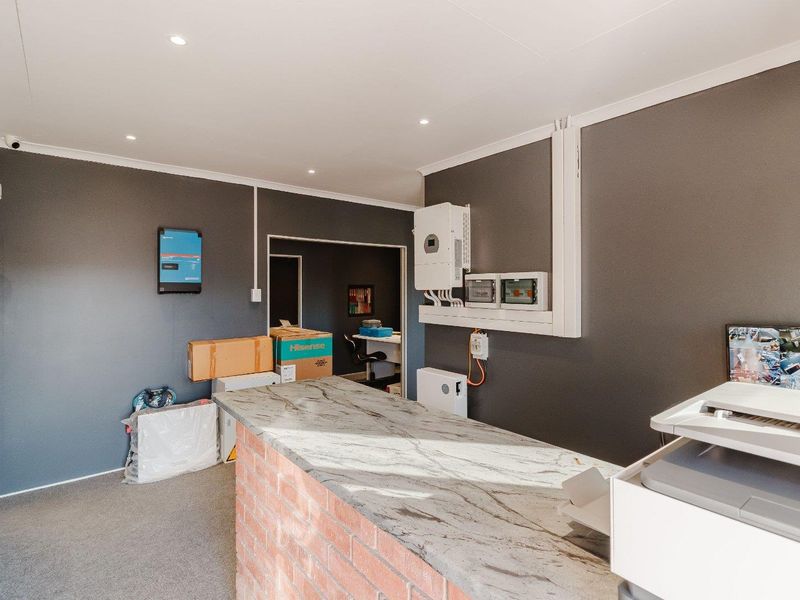 A functional office space featuring a brick counter with a stone top, integrated solar power infrastructure, and recessed lighting.