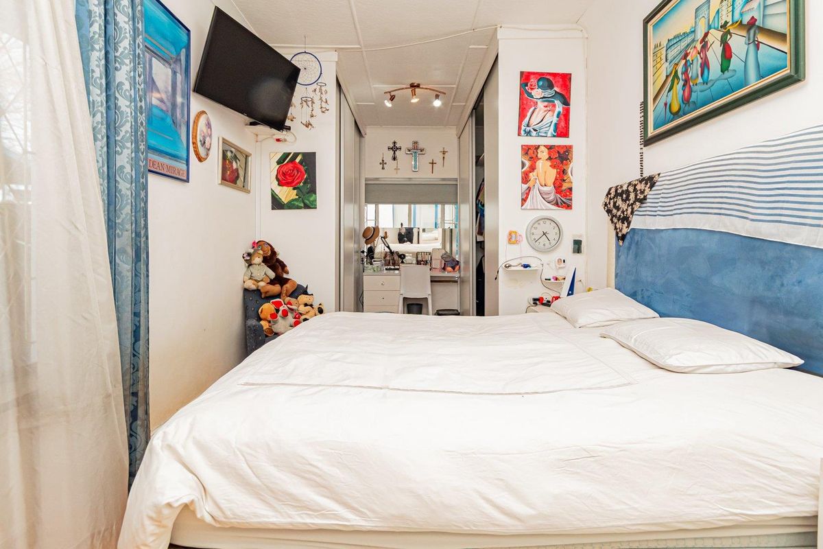 A bedroom featuring built-in cupboards and a dedicated vanity area, providing functional storage and a private space for daily routines.