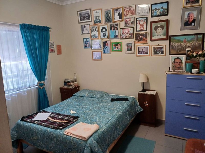 A functional bedroom featuring tiled flooring and a window with fitted blinds, providing a neutral space ready for personalization.
