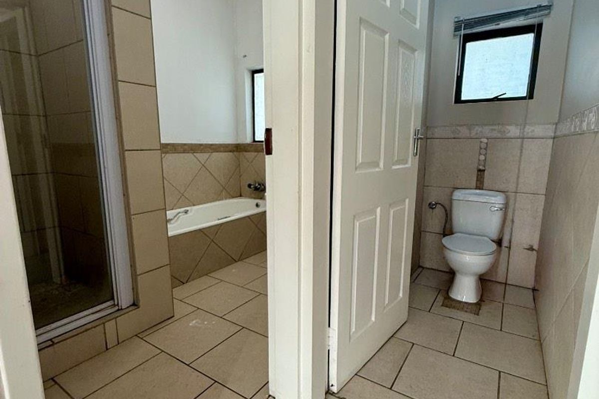A functional bathroom layout featuring a separate shower cubicle, a built-in bathtub, and a private toilet area with tiled finishes.