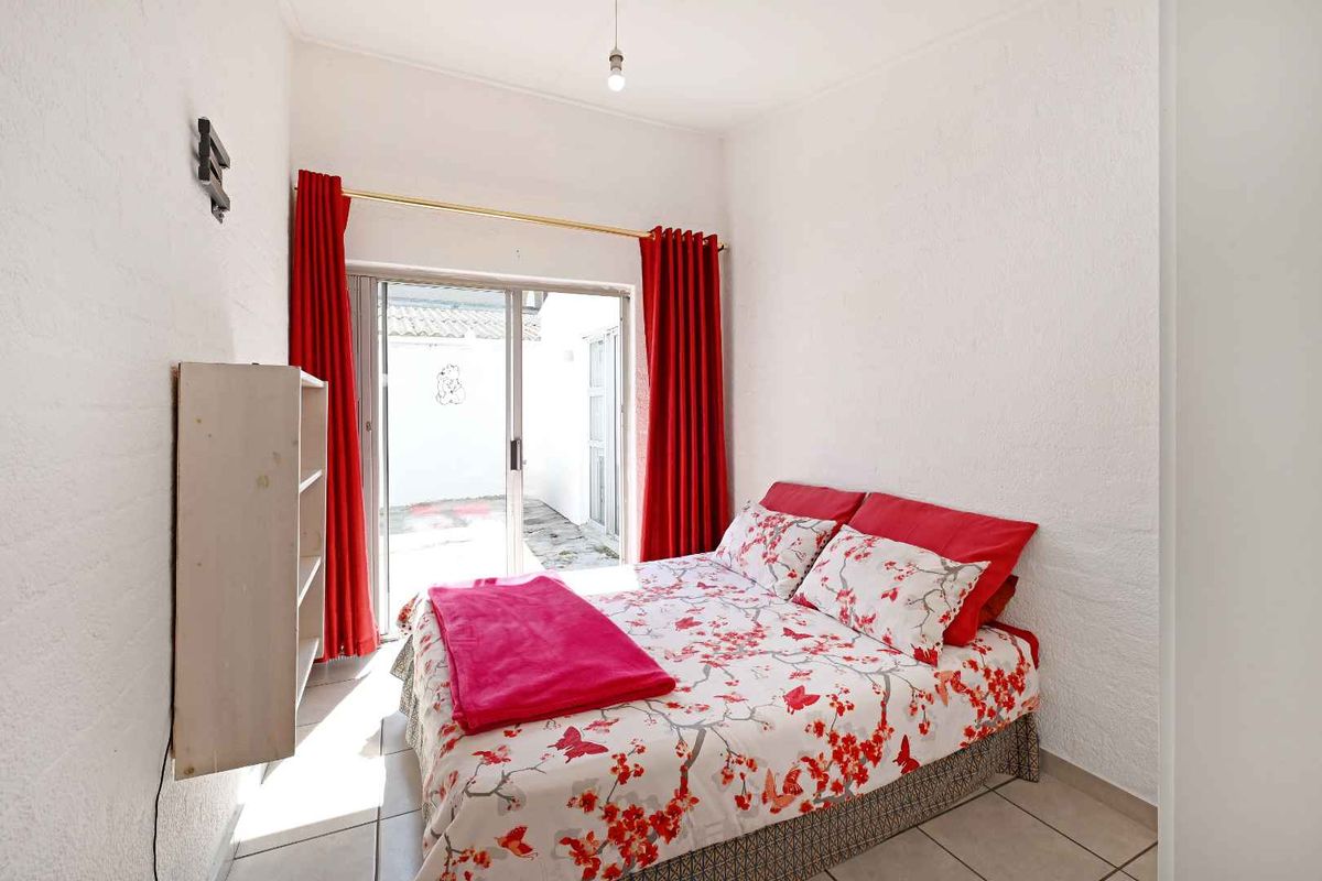 A bedroom featuring tiled flooring, textured walls, and a sliding glass door providing direct access to an outdoor area.