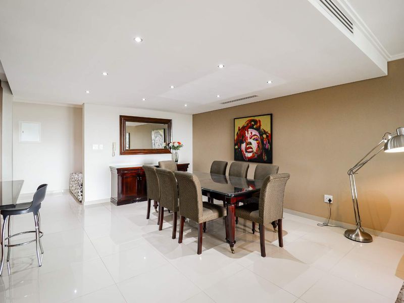 Spacious dining area featuring polished porcelain floor tiles, recessed downlighting, and integrated ducted air conditioning, creating a bright and modern living space.