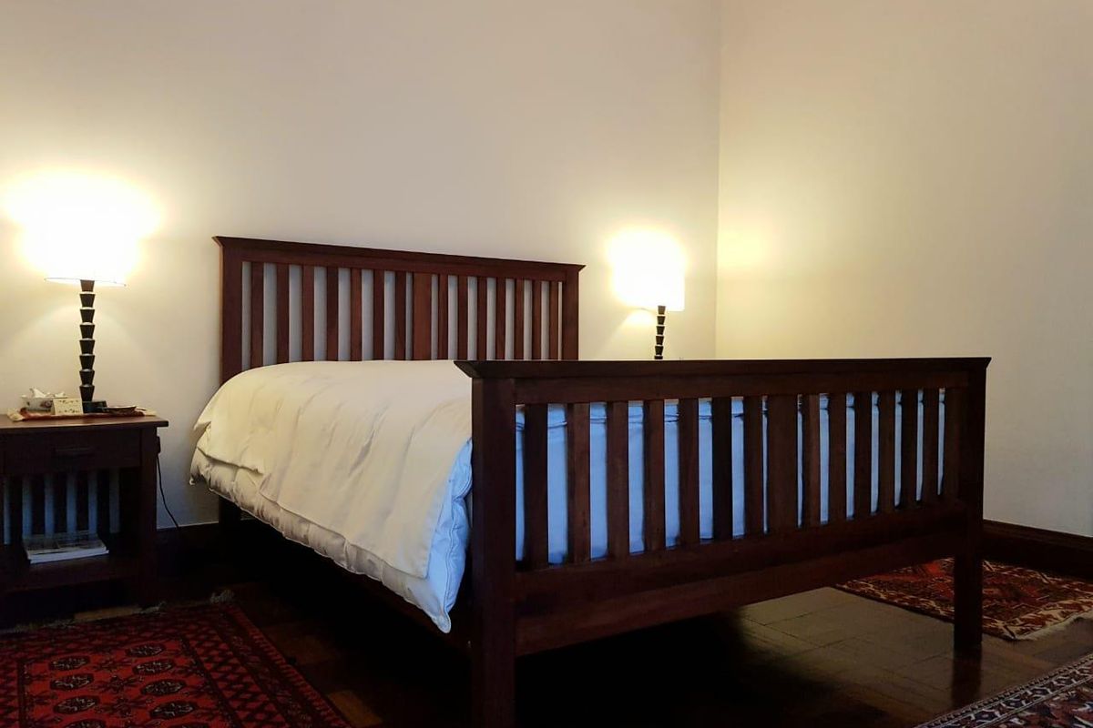 A well-maintained bedroom featuring polished timber flooring and neutral wall finishes, providing a comfortable and classic living space.