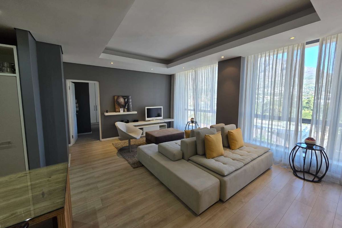 Modern living room featuring laminate flooring, recessed ceiling lighting, and expansive floor-to-ceiling windows offering natural light and views.