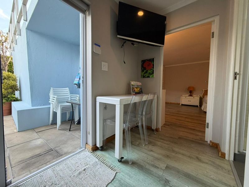 Living area featuring laminate flooring and a sliding glass door providing access to an outdoor patio space.