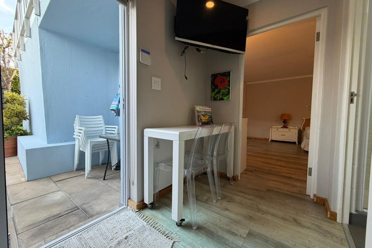 Living area featuring laminate flooring and a sliding glass door providing access to an outdoor patio space.