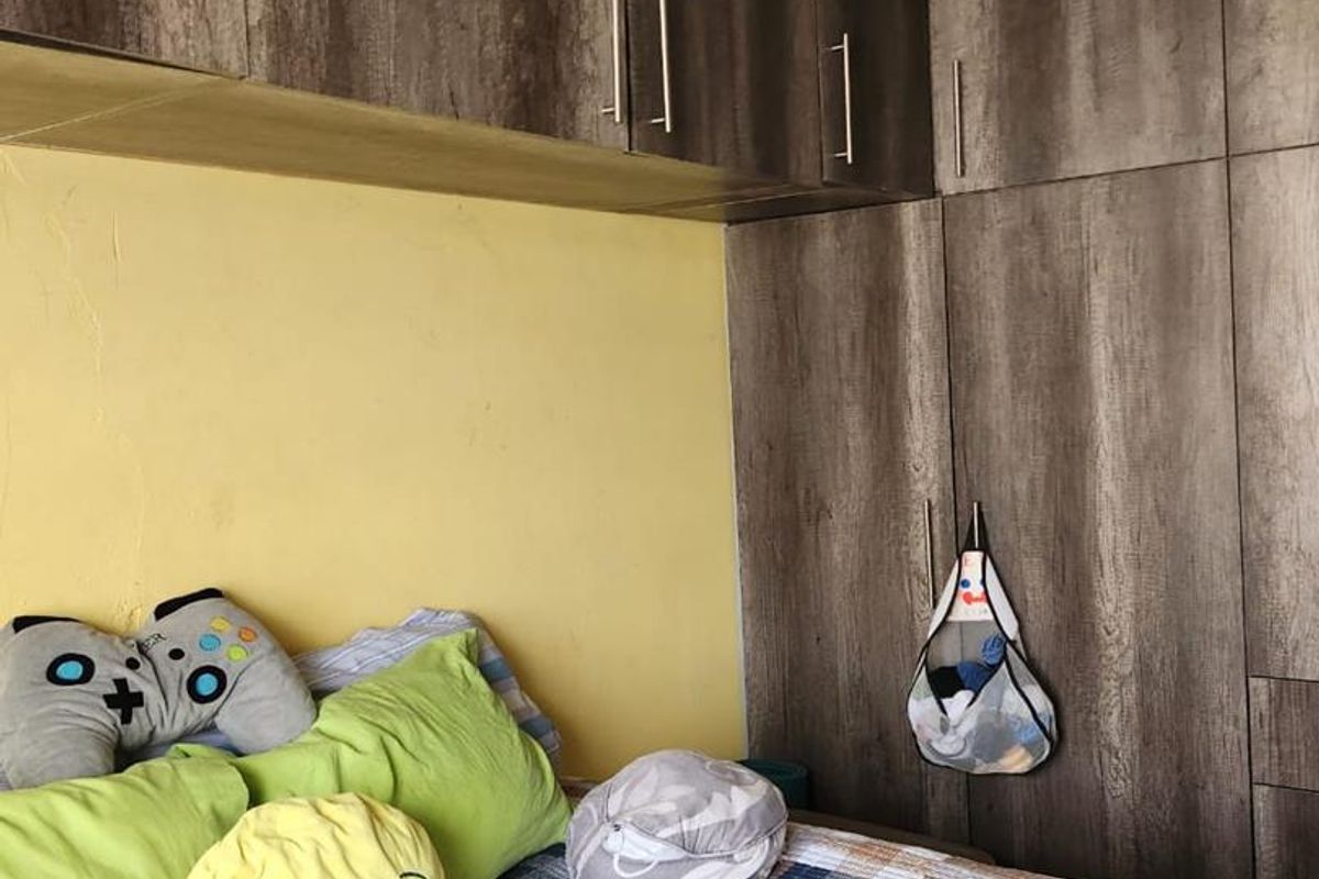 Bedroom featuring extensive built-in wooden cabinetry and wardrobe storage, providing ample space for organization.