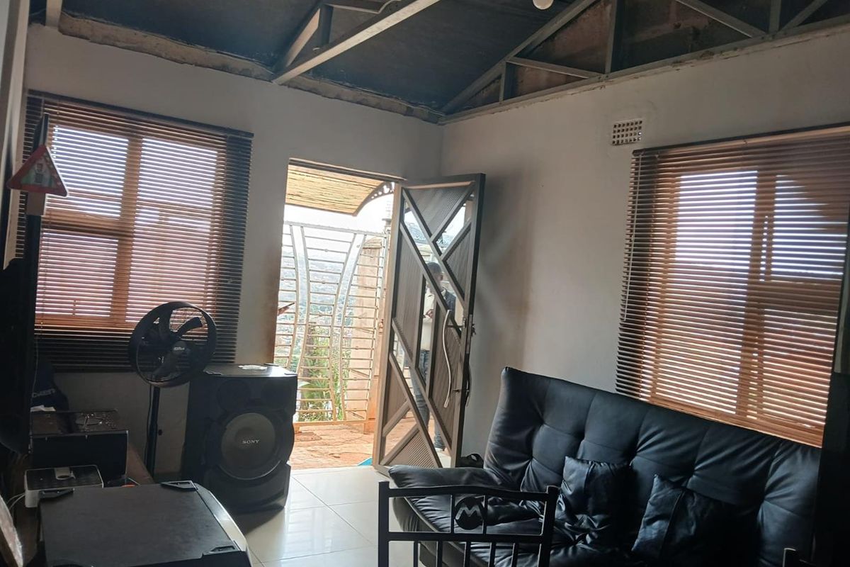 Living room featuring tiled floors, venetian blinds, and an exposed roof structure, providing a basic shell ready for interior finishing and ceiling installation.