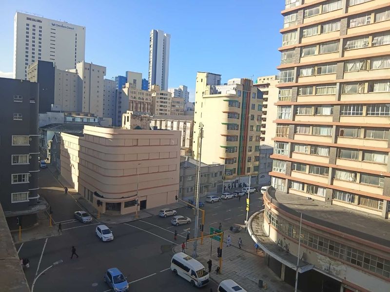 An elevated urban view overlooking a city intersection surrounded by high-rise apartment buildings and commercial structures.