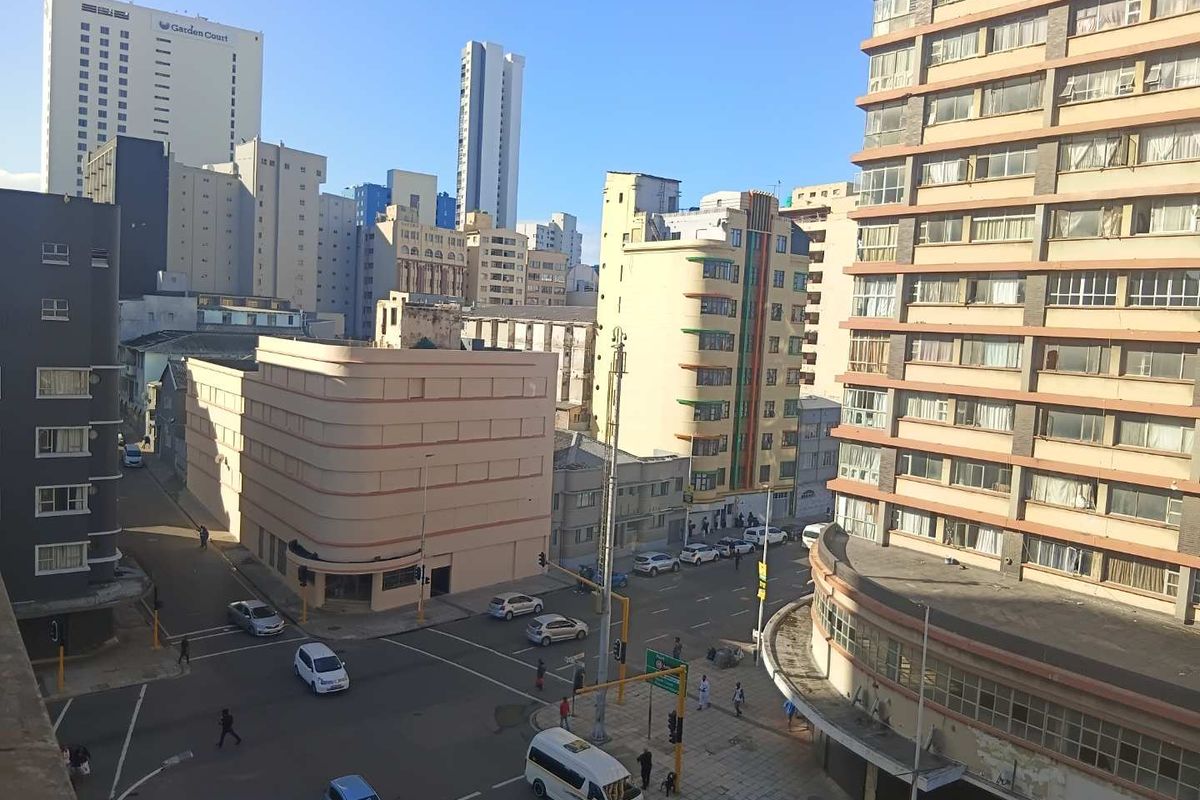 An elevated urban view overlooking a city intersection surrounded by high-rise apartment buildings and commercial structures.