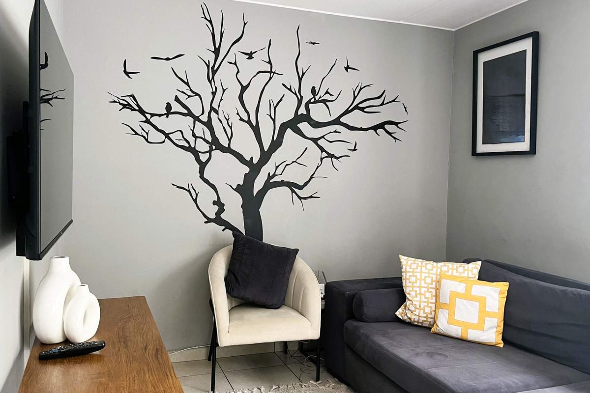 A living room area featuring neutral wall paint and tiled flooring, providing a functional space for relaxation.
