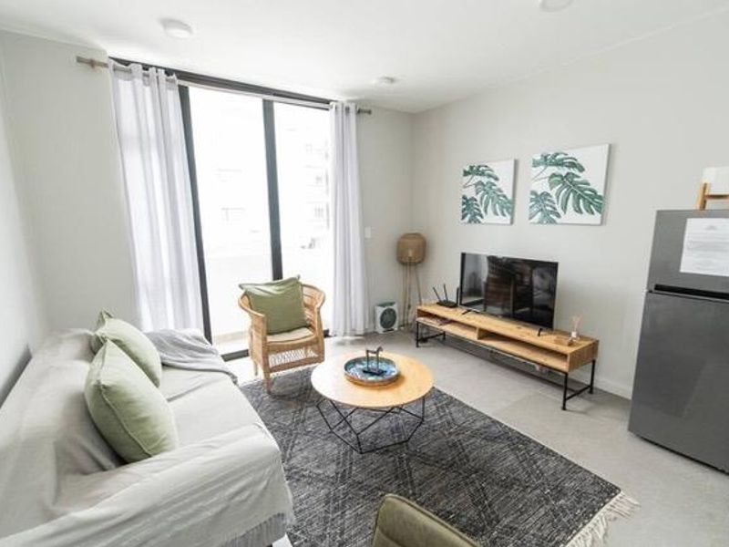 A bright and modern living room featuring large sliding glass doors that provide ample natural light and access to an outdoor area.