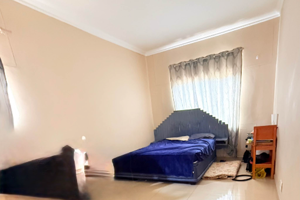 A bedroom featuring tiled flooring and a built-in headboard, presented with significant image distortion.