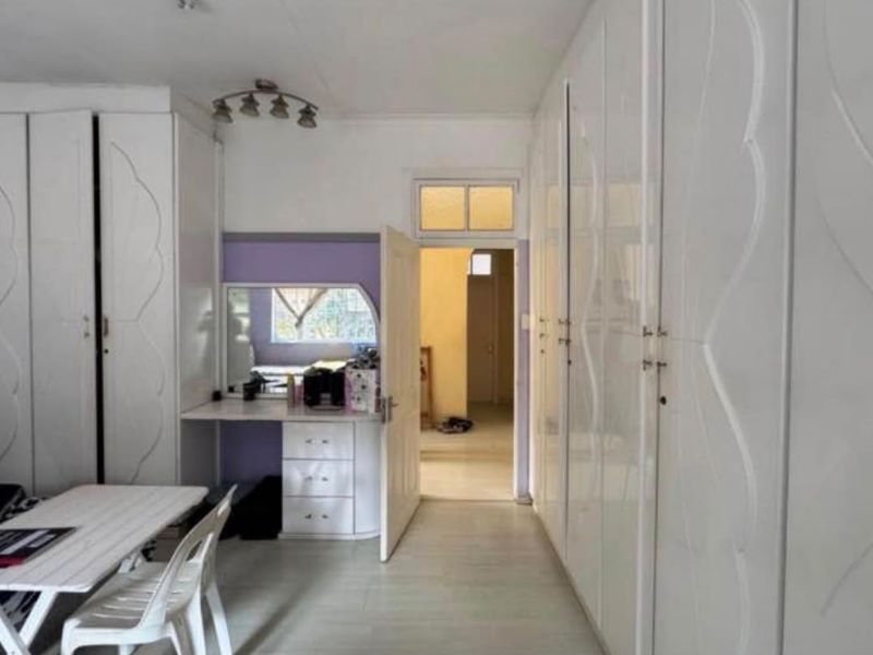Bedroom featuring extensive white built-in cupboards and a matching built-in vanity unit with laminate flooring.