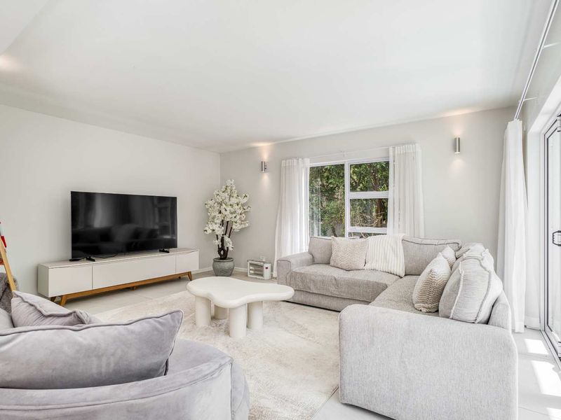 Bright and modern living room featuring large sliding glass doors that provide natural light and access to the outdoor area.