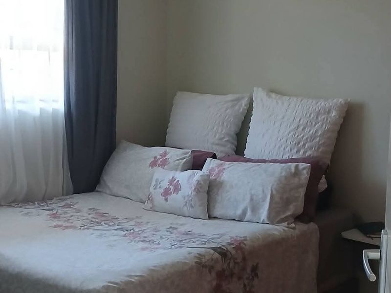 A compact bedroom featuring tiled flooring and a standard ceiling light fixture, providing a functional sleeping space.