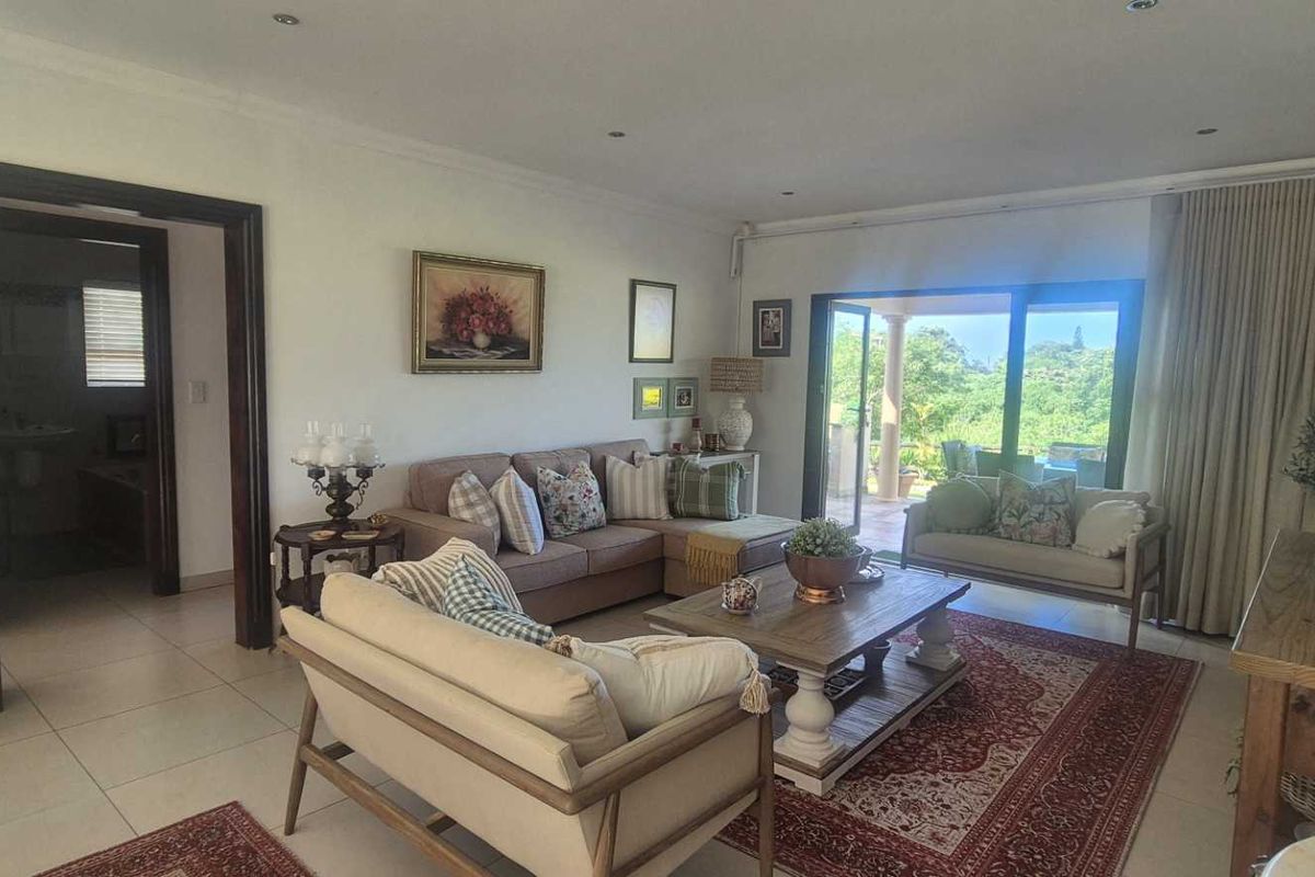 Spacious living room featuring tiled flooring, recessed lighting, and large sliding glass doors that provide access to the outdoor patio area.