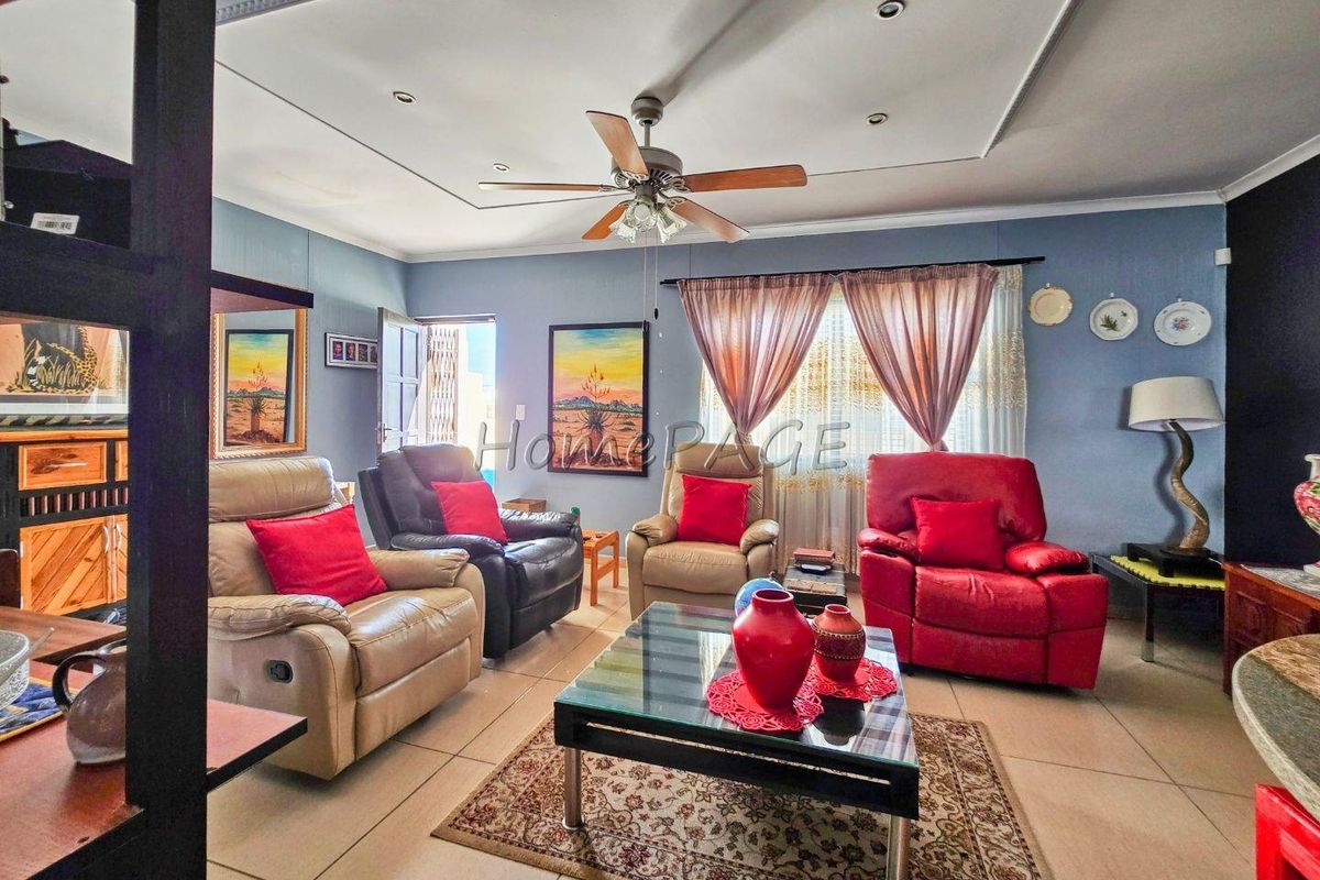 A living room featuring tiled flooring, a ceiling fan, and recessed lighting with decorative cove molding.