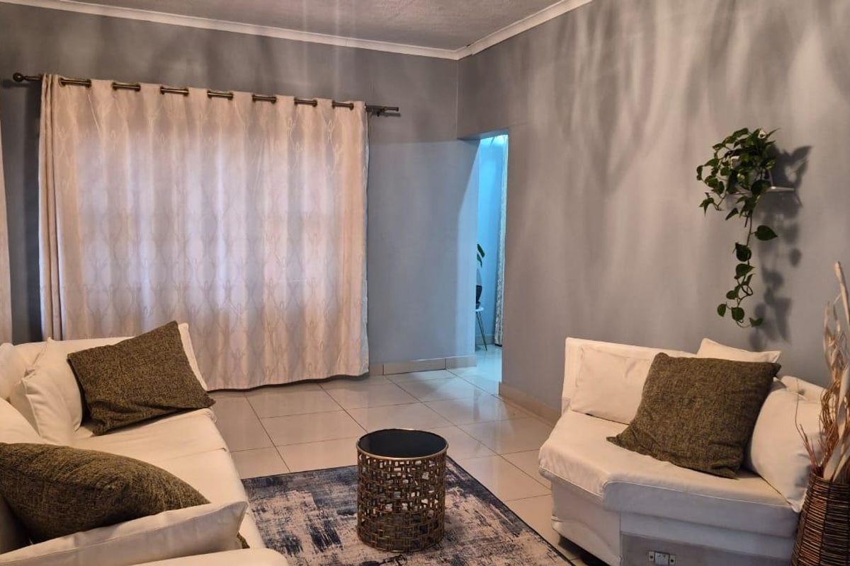 A living room featuring tiled flooring and neutral wall tones, providing a functional and comfortable space for relaxation.