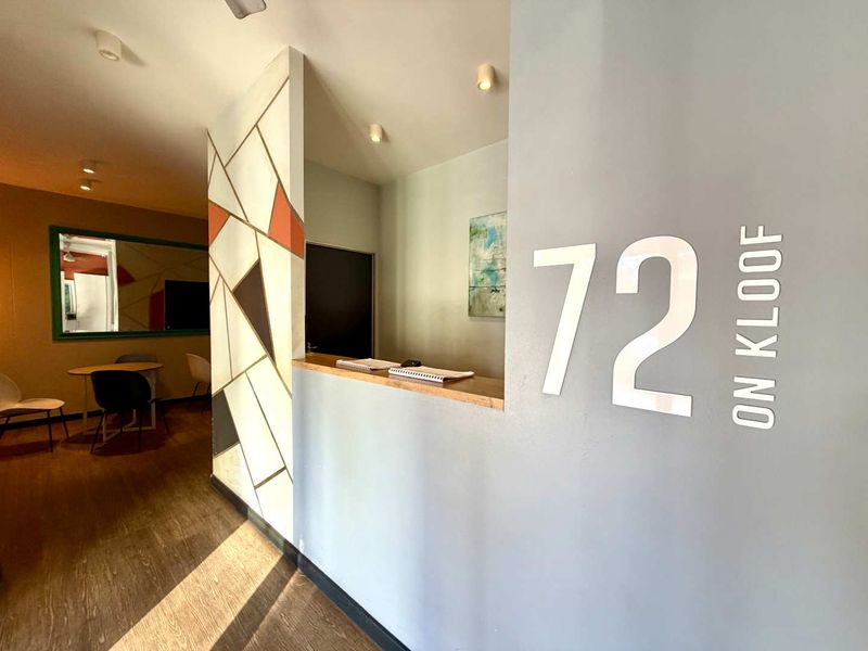 A modern apartment building entrance or reception area featuring a reception counter, feature wall, and recessed lighting.