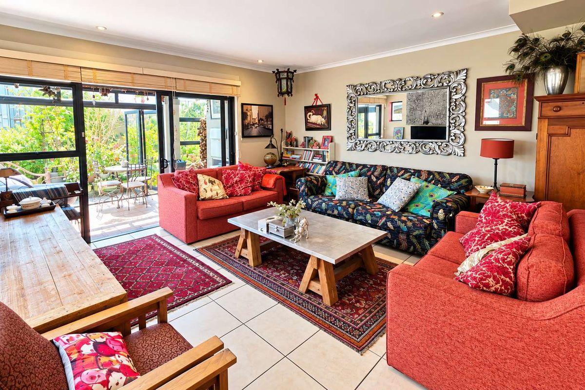 A spacious living room featuring tiled flooring, recessed lighting, and large sliding glass doors that provide direct access to the outdoor patio area.