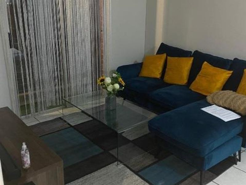 A living room area featuring tiled flooring and a sliding glass door providing access to the exterior.