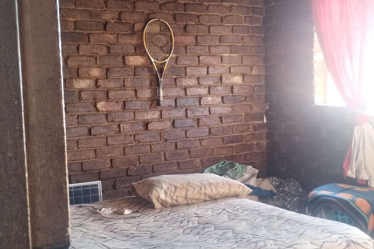 A bedroom featuring an exposed brick wall, providing a rustic aesthetic that could be enhanced with modern finishes and updated lighting.