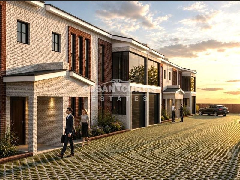Modern townhouse development featuring a brick facade, paved driveway, and covered entrances, showcasing contemporary architectural design.