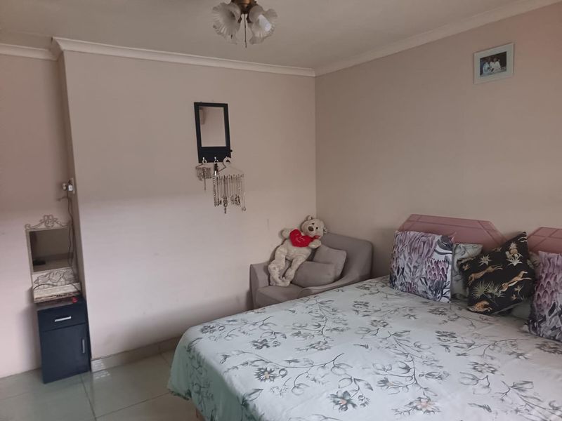 A standard bedroom featuring tiled flooring, coving, and a central ceiling light fixture.