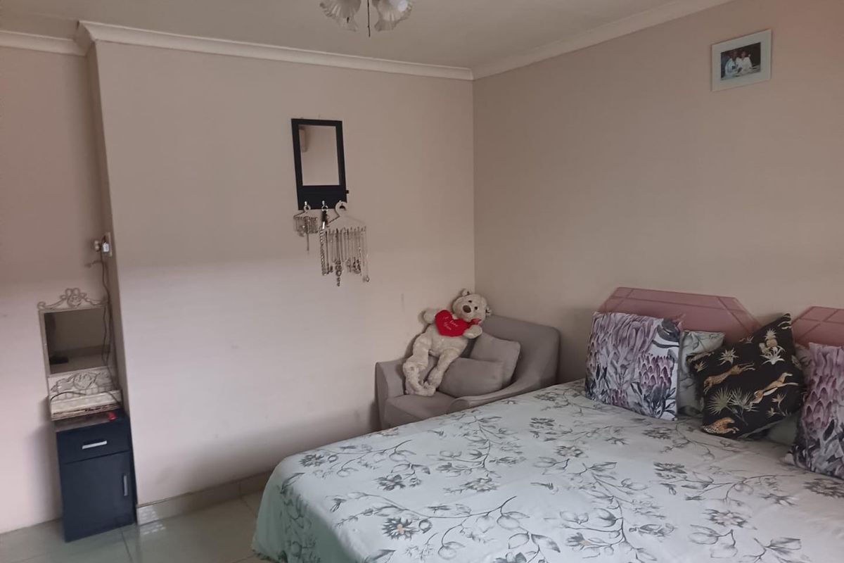 A standard bedroom featuring tiled flooring, coving, and a central ceiling light fixture.