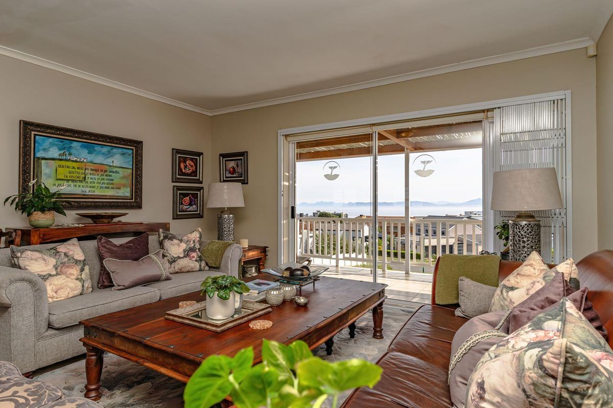A comfortable living room featuring sliding glass doors that open onto a balcony with scenic coastal views.
