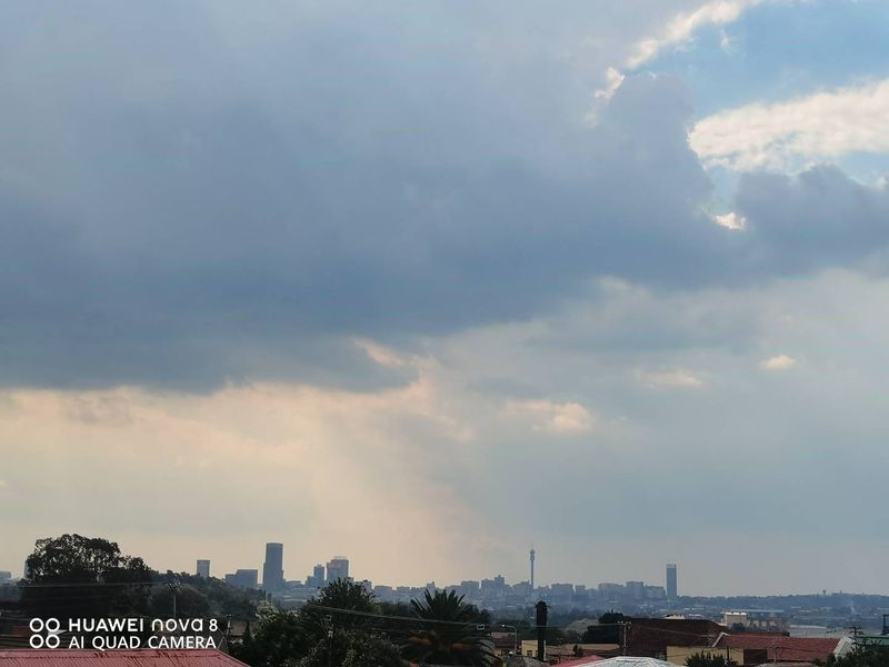 A distant view of the city skyline under a cloudy sky, captured from an elevated position.