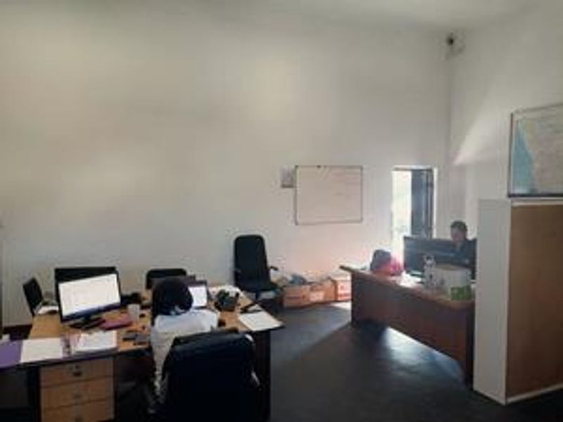 A functional office space featuring a whiteboard and security camera, providing a practical environment for daily business operations.