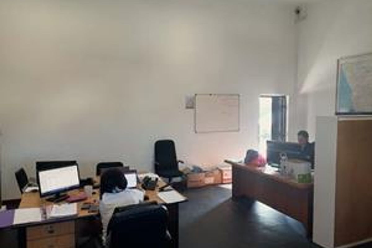 A functional office space featuring a whiteboard and security camera, providing a practical environment for daily business operations.