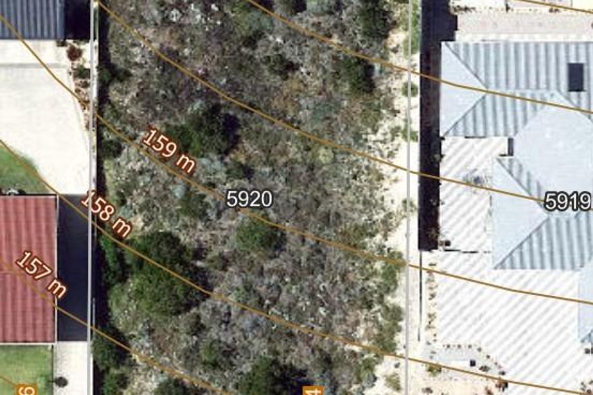 An aerial view of a vacant residential plot showing site boundaries and surrounding properties.