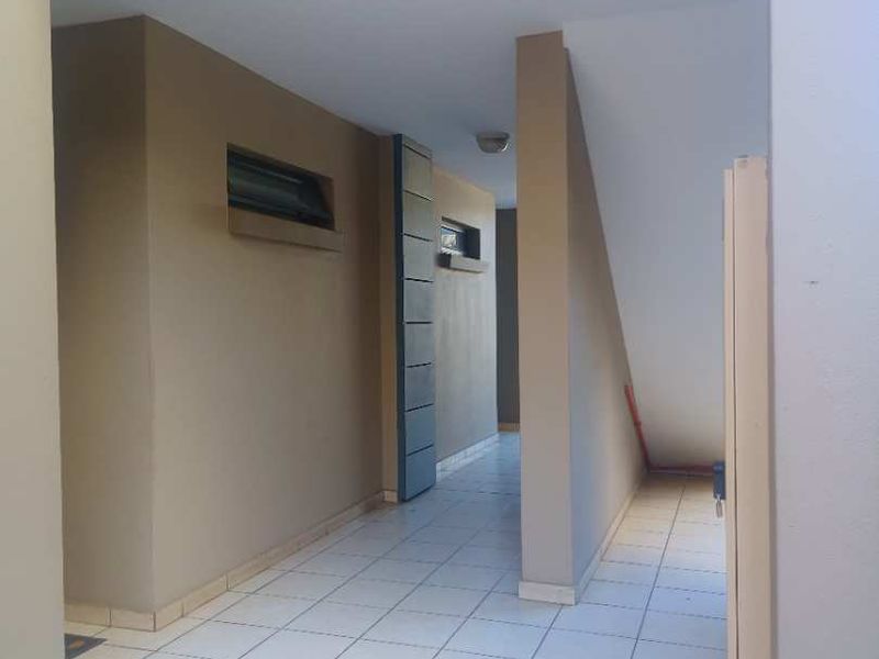 A clean, tiled entrance area or hallway featuring neutral wall tones and recessed lighting, providing a functional transition space within the apartment.
