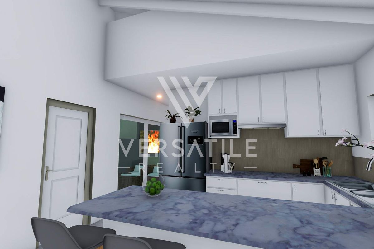 Modern kitchen featuring white cabinetry, stone countertops, and a vaulted ceiling, integrated with a breakfast bar area.