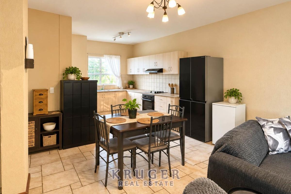 Open-plan kitchen and dining area featuring light wood cabinetry, tiled flooring, and a functional layout with integrated cooking appliances.