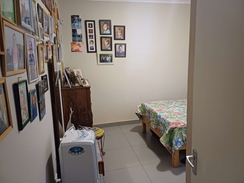 A functional bedroom featuring neutral wall tones and tiled flooring, offering a clean and simple space for rest.
