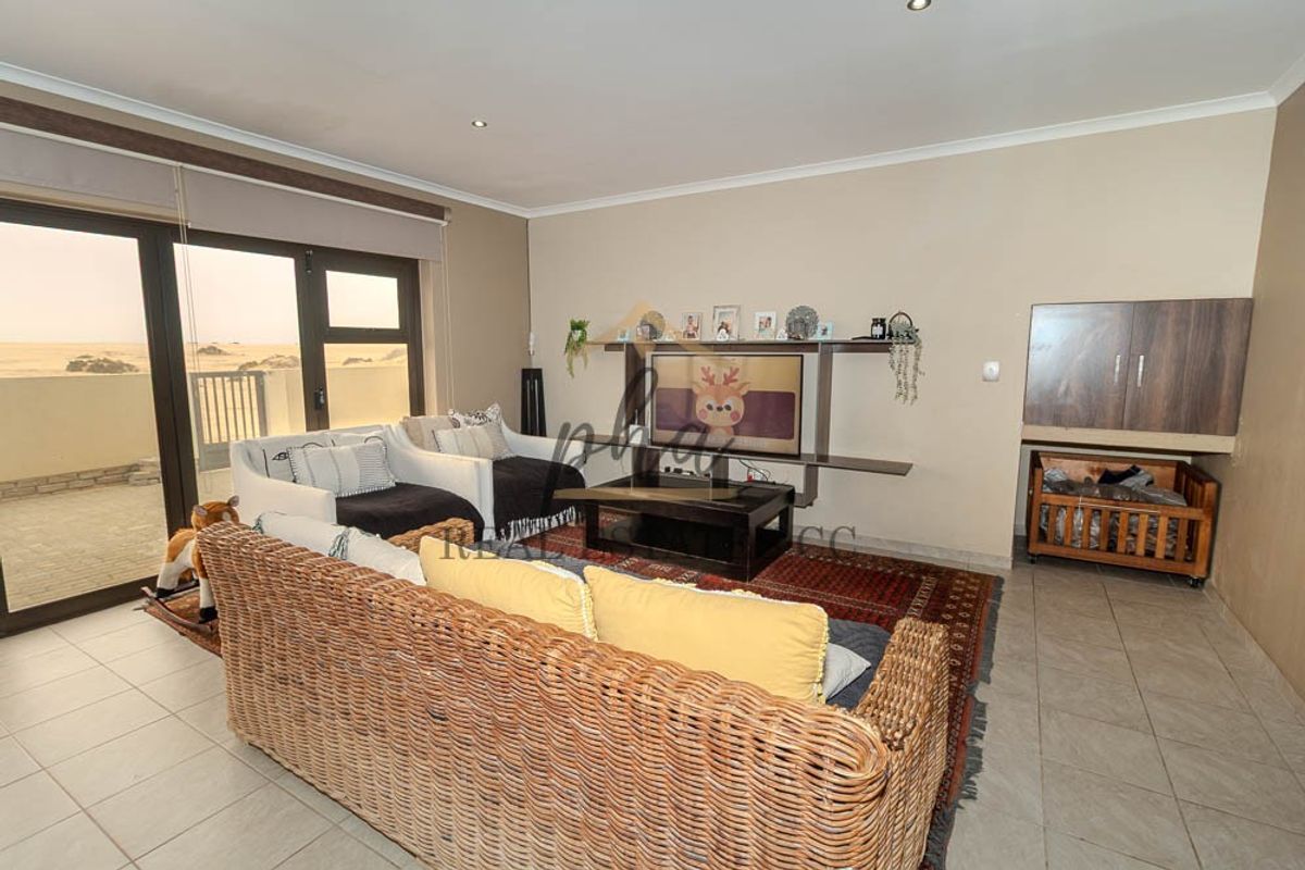 Spacious living room featuring tiled flooring, recessed lighting, and large sliding glass doors that provide access to an outdoor area.