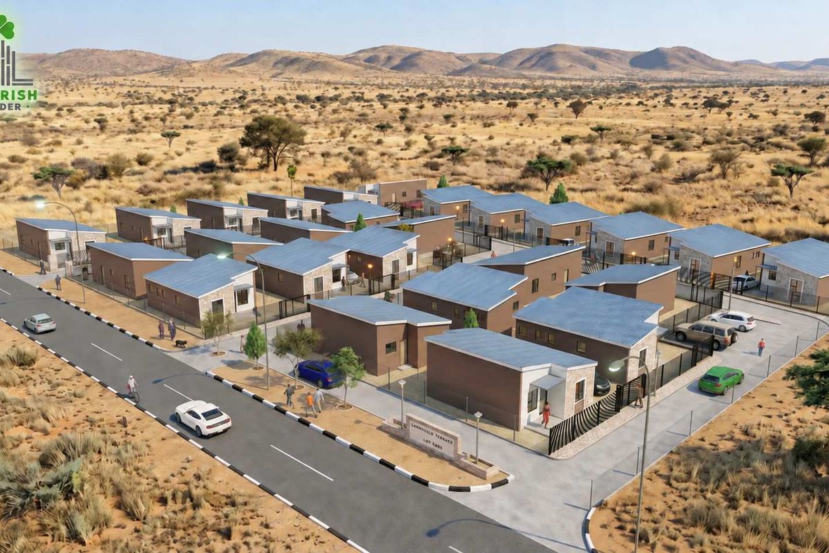 An aerial perspective of a modern residential housing development featuring multiple detached units, paved roads, and perimeter fencing in a desert landscape.