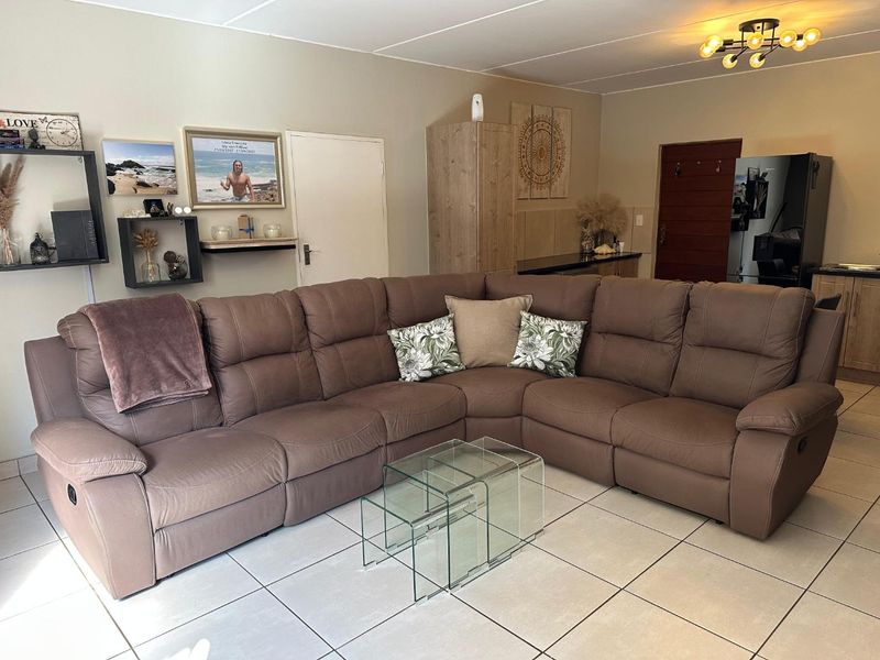 Open plan living area featuring tiled flooring and integrated cabinetry, providing a functional space that connects the lounge and kitchen zones.
