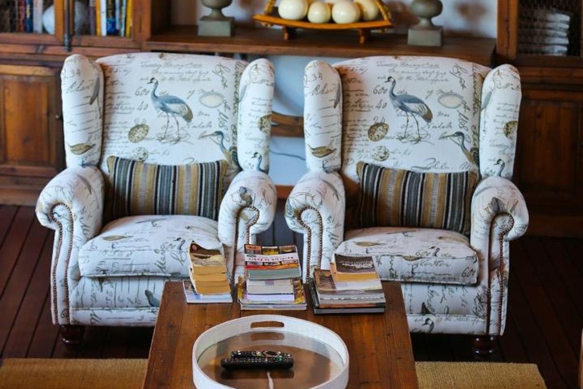 A cozy lounge area featuring built-in wooden display cabinetry and dark timber flooring, creating a warm and inviting atmosphere.