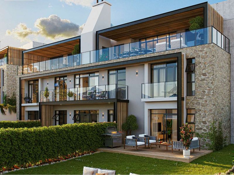 Modern apartment building exterior featuring stone cladding, expansive glass balustrades, timber-lined balconies, and a ground-floor timber deck overlooking a landscaped garden.