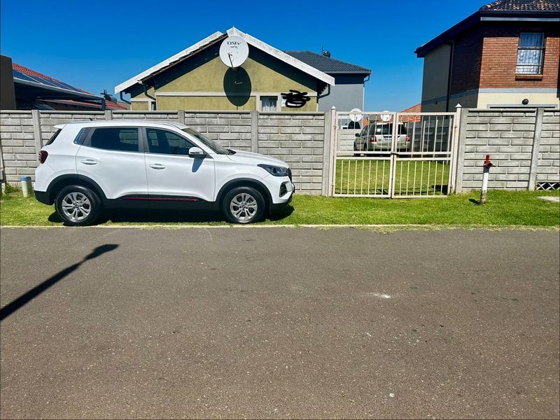 Street view showing the property boundary with a precast concrete wall and metal gate access.