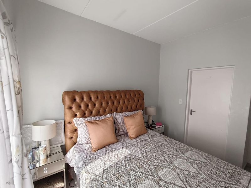 A well-maintained bedroom featuring neutral wall finishes and a standard internal door, providing a clean and comfortable living space.